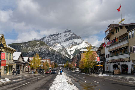 Street view of Banff Avenue in autumn and winter snowy season sunny day during covid-19 pandemic period. Banff, Alberta, Canada.のeditorial素材