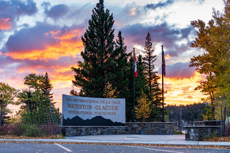 Waterton-Glacier International Peace Park in autumn foliage season. Waterton lake shore at dawn, beautiful fiery clouds in sunrise time. Waterton Lakes National Park, Alberta, Canada.のeditorial素材
