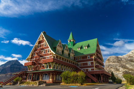 Prince of Wales Hotel in autumn sunny day morning. Blue sky, white clouds over mountains in the background. Landmarks in Waterton Lakes National Park, Alberta, Canada.のeditorial素材