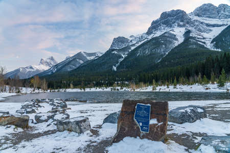 Quarry Lake at dusk in early winter season. Sky of pink clouds, snow capped Mount Lawrence Grassi in the background. Canmore, Alberta, Canada.のeditorial素材