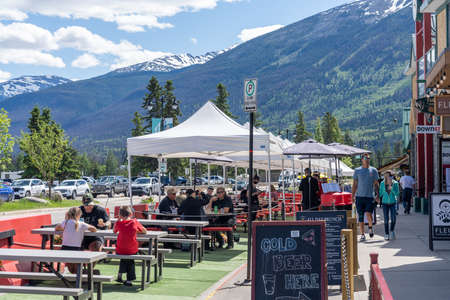 Jasper, Alberta, Canada-June 17 2021: Town Jasper street view in summer during covid-19 pandemic period. People seating sidewalk dining outside the restaurants.のeditorial素材
