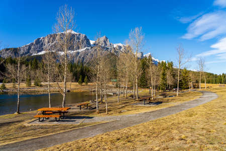 Quarry Lake park lakeshore in late autumn season sunny day morning. Snow capped Mount Rundle mountains in with blue sky in the background. Canmore, Alberta, Canada.の写真素材
