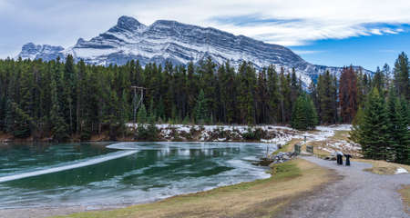 Johnson Lake frozen water surface in winter time. Snow-covered Mount Rundle in the background. Banff National Park, Canadian Rockies, Alberta, Canada.の写真素材