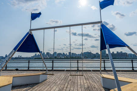 A swing in the Jean-Drapeau park maritime shuttle landing stage. Saint Helens Island in sunset time. Montreal, Quebec, Canada.の写真素材