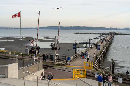 White Rock, BC, Canada-March 31 2021: People stroll along the famous 1,500 ft. long pier in the dusk.のeditorial素材