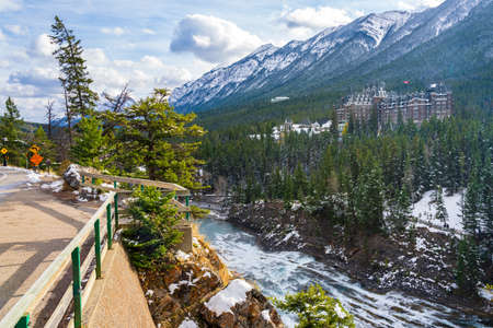 Fairmont Banff Springs and Bow River Falls in snowy autumn sunny day. View from Surprise Corner Viewpoint. Banff National Park, Canadian Rockies.のeditorial素材