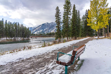 Banff Pedestrian Bridge and Bow River trail in snowy autumn day. Banff National Park, Canadian Rockies.の写真素材