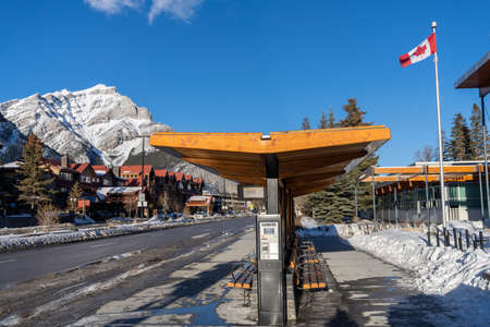 Banff, Alberta, Canada - January 23 2022 : Street view of Town of Banff. Bus stop on Banff Avenue in winter snowy season.のeditorial素材