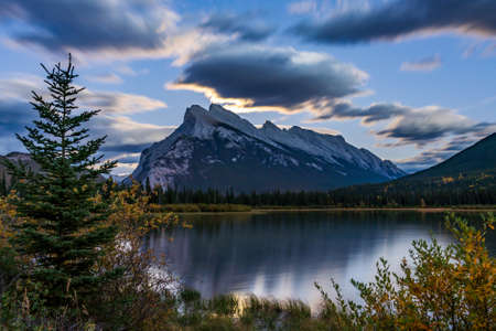 Moonrise at Vermilion Lakes in summer night. Banff National Park, Canadian Rockies, Alberta, Canada. Bright full moon over Mount Rundle and light up the night with golden reflection on lake surface.の写真素材