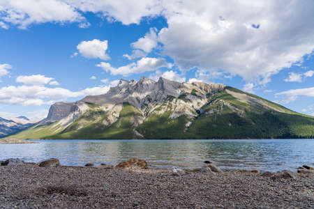 Lake Minnewanka beautiful landscape in summer day. Famous tourist attraction for leisure activities, boat cruise and mountain trail hiking in Banff National Park, Canadian Rockies.の写真素材