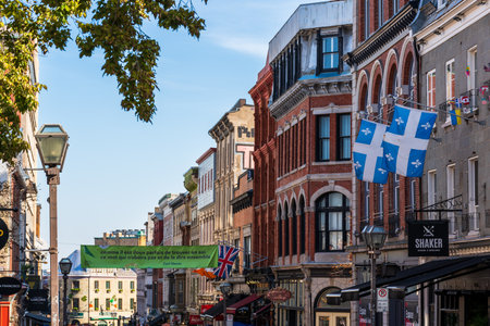 Quebec, Canada - October 23 2022 : Flag of Quebec. Quebec City Old Town. Restaurant and gift shop on Rue Saint-Jean.のeditorial素材