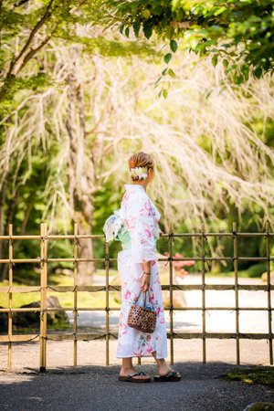 Portrait of a young woman wearing yukata summer kimono with soft blur background in a Japanese garden. Kyoto, Japan.の写真素材