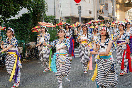 Osaka, Japan - July 25 2023 : Tenjin Matsuri Festival. Umbrella dancers walking through the streets.