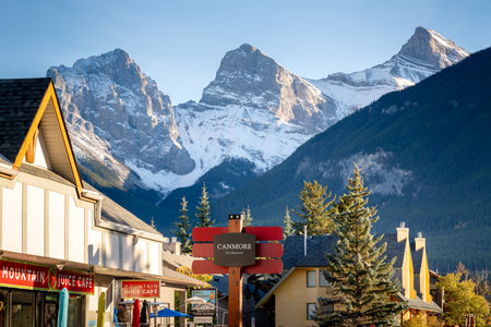 Canmore, AB, Canada - Oct 7 2023 : Canmore Town Sign. The Three Sisters trio of peaks over the blue sky in the background.のeditorial素材