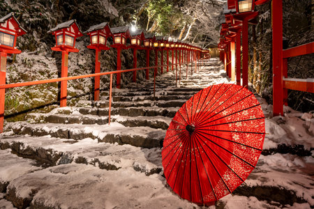 Kyoto, Japan. Kifune shrine traditional light pole in snowy winter night. Japanese umbrella on the stone stairs. Concept of Japanese culture.の写真素材