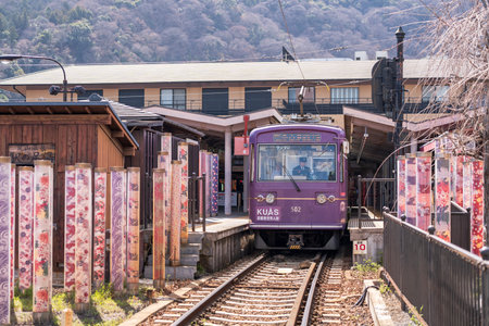 Kyoto, Japan - March 29 2024 : Train stop at Arashiyama station with the Kimono forest poles on both sides of the platform. Arashiyama Line operated by Keifuku Electric Railroad.のeditorial素材