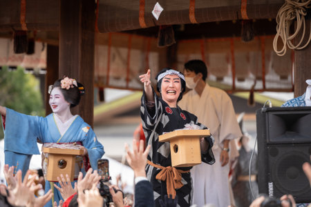 Kyoto, Japan - February 2 2024 : Yasaka Shrine Setsubun festival roasted beans scattering ceremony "mamemaki". Maiko throwing the fortune beans.のeditorial素材