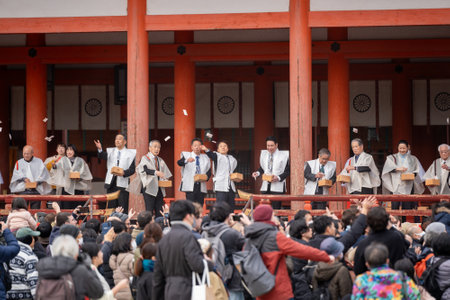 Kyoto, Japan - February 3 2024 : Heian Jingu Shrine Setsubun festival roasted beans scattering ceremony "mamemaki". Shrine staff throwing the fortune beans.のeditorial素材