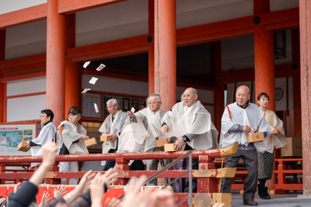 Kyoto, Japan - February 3 2024 : Heian Jingu Shrine Setsubun festival roasted beans scattering ceremony "mamemaki". Shrine staff throwing the fortune beans.のeditorial素材
