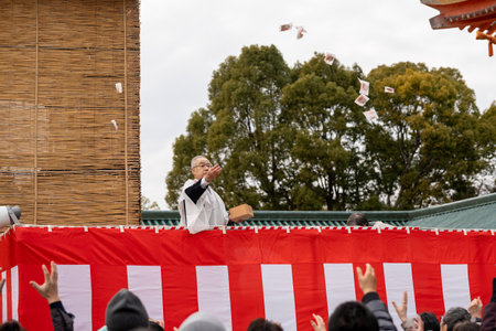 Kyoto, Japan - February 3 2024 : Heian Jingu Shrine Setsubun festival roasted beans scattering ceremony "mamemaki". Shrine staff throwing the fortune beans.のeditorial素材