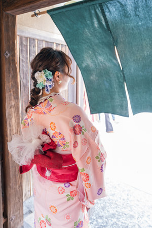 back view of asian woman in kimono looking at windowの写真素材