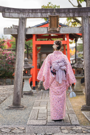 Japanese woman wearing traditional kimono walking in a Japanese garden.の写真素材