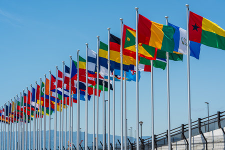 International Flags flying high against clear sky at the Entrance of Expo 2025 Osaka Kansaiの写真素材