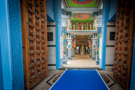 Singapore - October 21st 2015: View into open wooden doors looking towards religious shrines in the colorful and vibrant Sri Srinivasa Perumal Temple on Serangoon Road in Little India, Singapore, Asiaのeditorial素材