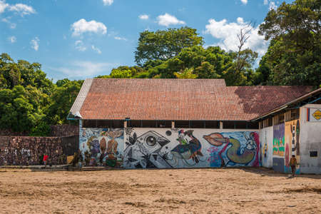 An urban building near the Ponta Negra beach in the Amazon with a local young Brazilian boy playing with a football on a dirty sandy floor on a hot summer day in Manaus, the Amazon, Brazil, South Americaのeditorial素材