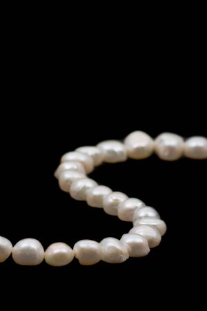 Beautiful white pearl necklace over black backgroundの写真素材