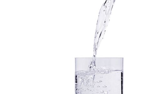 Fresh water being poured into glass isolated on white background