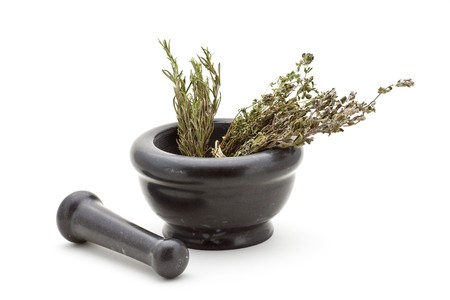 Different dried herbs in stone mortar over white backgroundの写真素材