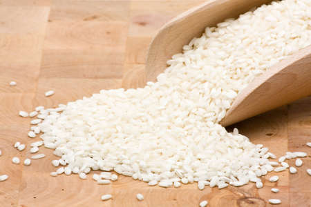 Basmati rice in wooden scoop on tableの写真素材