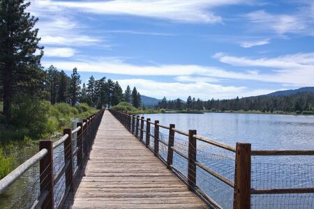 Bridge at beautiful mountain lake with nice cloudsの写真素材