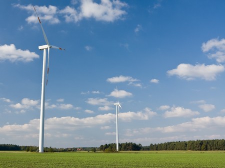 Wind mill in green field with clouds - renewable energy source conceptの写真素材