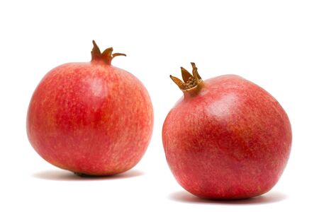 Two delicious fresh pomegranates over white backgroundの写真素材