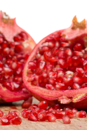 Delicious pomegranate with seeds on wooden tableの写真素材
