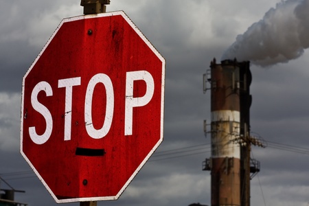 Smoke stack with STOP sign in foreground - environmental conceptの写真素材