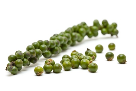Unprocessed fresh green peppercorns over white backgroundの写真素材