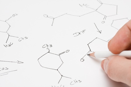Researcher or teacher writing chemical formula on paperの写真素材