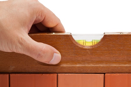 Craftsman measuring a brick wall with a spirit levelの写真素材