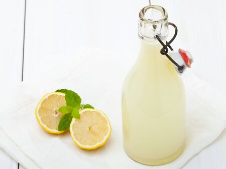 Fresh homemade bottle of lemonade on a wooden tableの写真素材