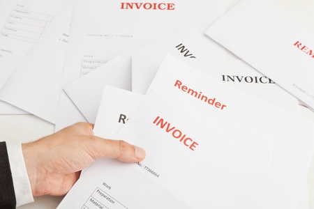 Business man holding numerous invoices and remindersの写真素材