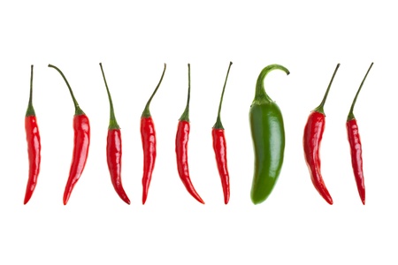 Birds eye chilis and one jalapeno chili in a row isolated on white backgroundの写真素材