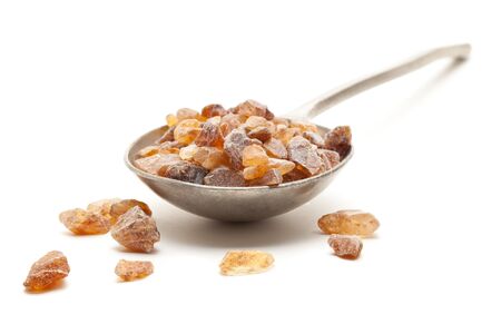 Organic rock candy sugar in spoon over white backgroundの写真素材
