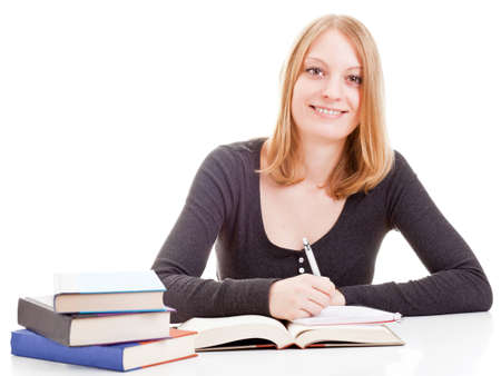 Young attractive female student taking notes from open book isolated on white backgroundの写真素材