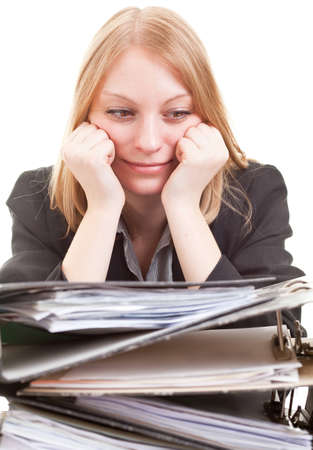 Young attractive businesswoman looks at huge stack of folders isolated on white backgroundの写真素材