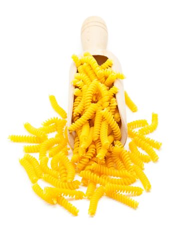 Fusilli  spiral-shaped pasta  in wooden scoop on white backgroundの写真素材