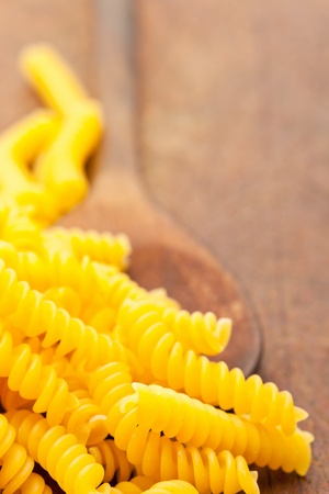 Fusilli  spiral-shaped pasta  on wooden spoon on cooking boardの写真素材