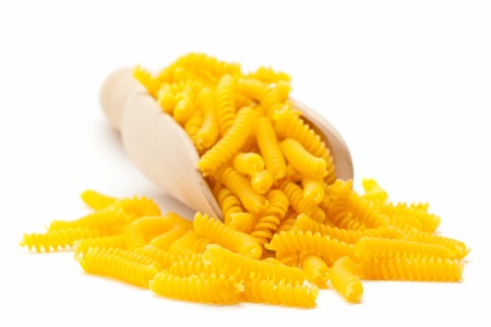Fusilli  spiral-shaped pasta  in wooden scoop on white backgroundの写真素材